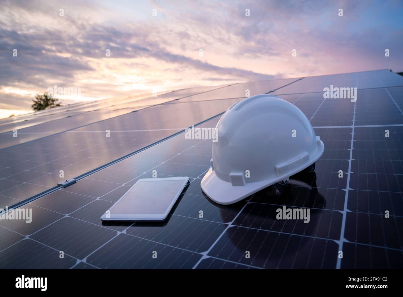 Helm mit Tablet auf dem Solarpanel für die Arbeit Solarstation Photovoltaik-Panels, Wissenschaft Solarenergie, Ingenieur arbeiten an der Überprüfung und Wartung Stockfoto