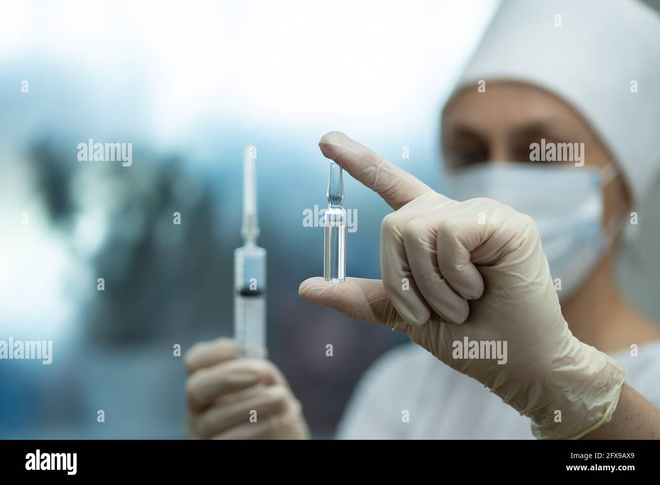 Medizinische Ampulle und Spritze in der Hand des Arztes. Stockfoto