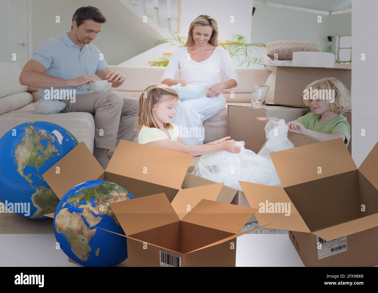 Zusammensetzung der glücklichen kaukasischen Familie in neuem Zuhause mit zwei Globen und Kartons Stockfoto