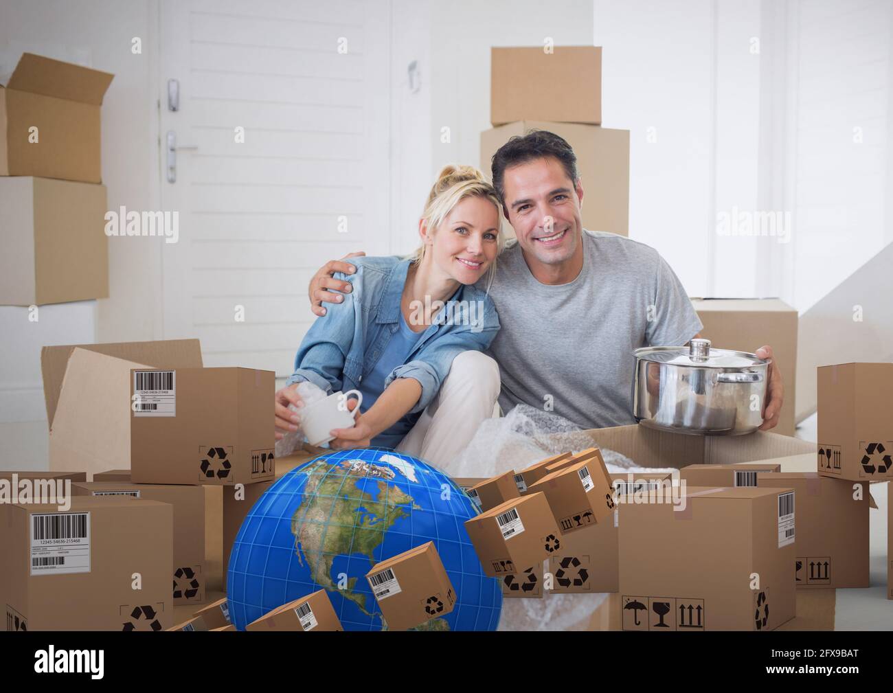 Komposition eines glücklichen kaukasischen Paares in einem neuen Zuhause mit Globus Und Kartons Stockfoto