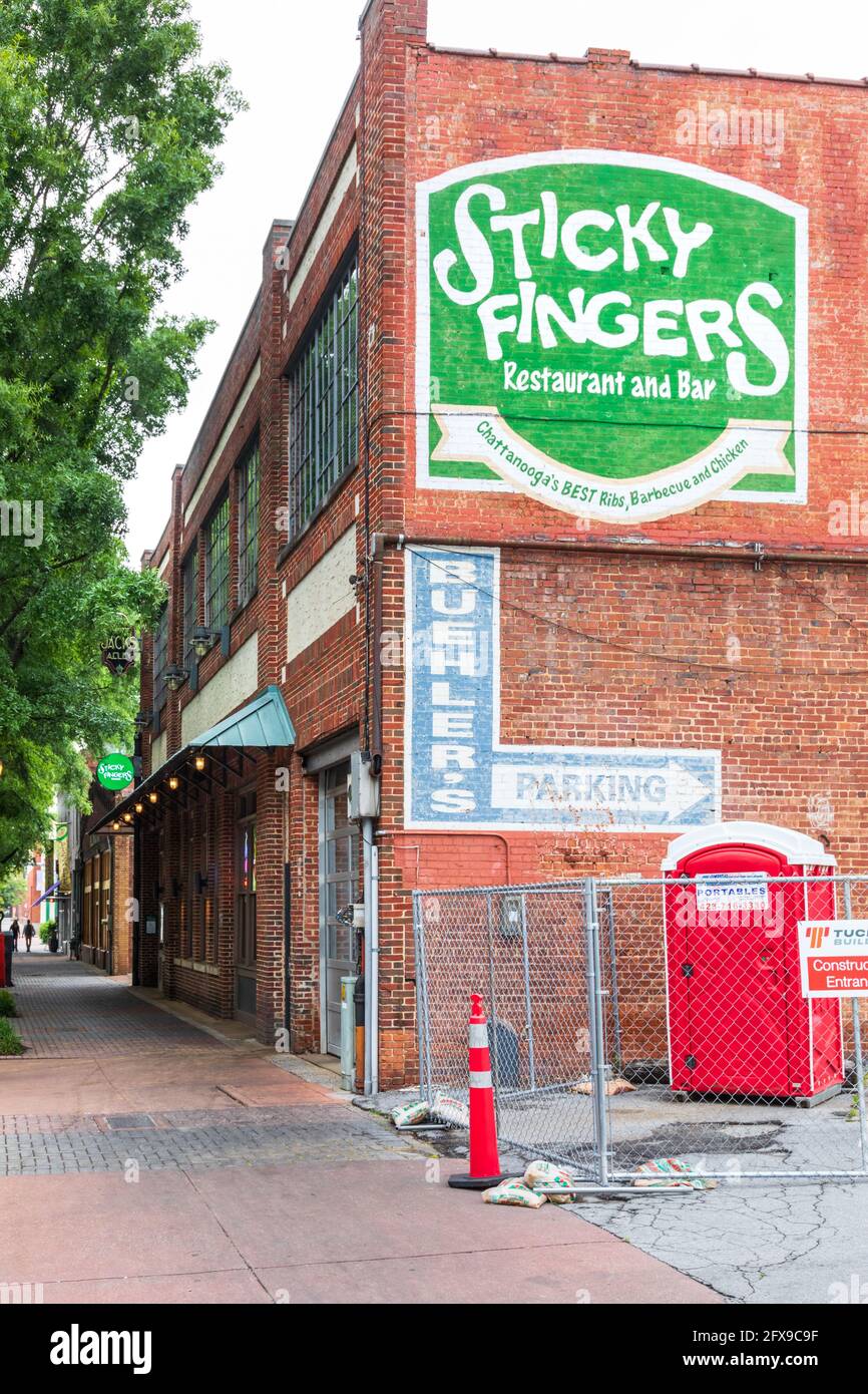 CHATTANOOGA, TN, USA-10 MAY 2021: Diagonale Straßenansicht von Sticky Fingers Ribhouse auf der Broad Street zeigt bemaltes Schild und Bürgersteig vor dem Restaurant. Stockfoto