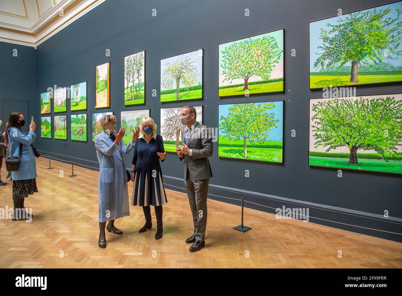 Die Herzogin von Cornwall (Mitte) blickt auf Werke des Künstlers David Hockney zusammen mit der Präsidentin der RAA, Rebecca Salter, und Axel Ruger, dem Sekretär und Geschäftsführer der Royal Academy of Arts, während eines Besuchs in der Royal Academy of Arts in London, um die Wiedereröffnung der Galerie nach der Lockerung der Einschränkungen durch das Coronavirus zu feiern. Bilddatum: Mittwoch, 26. Mai 2021. Stockfoto