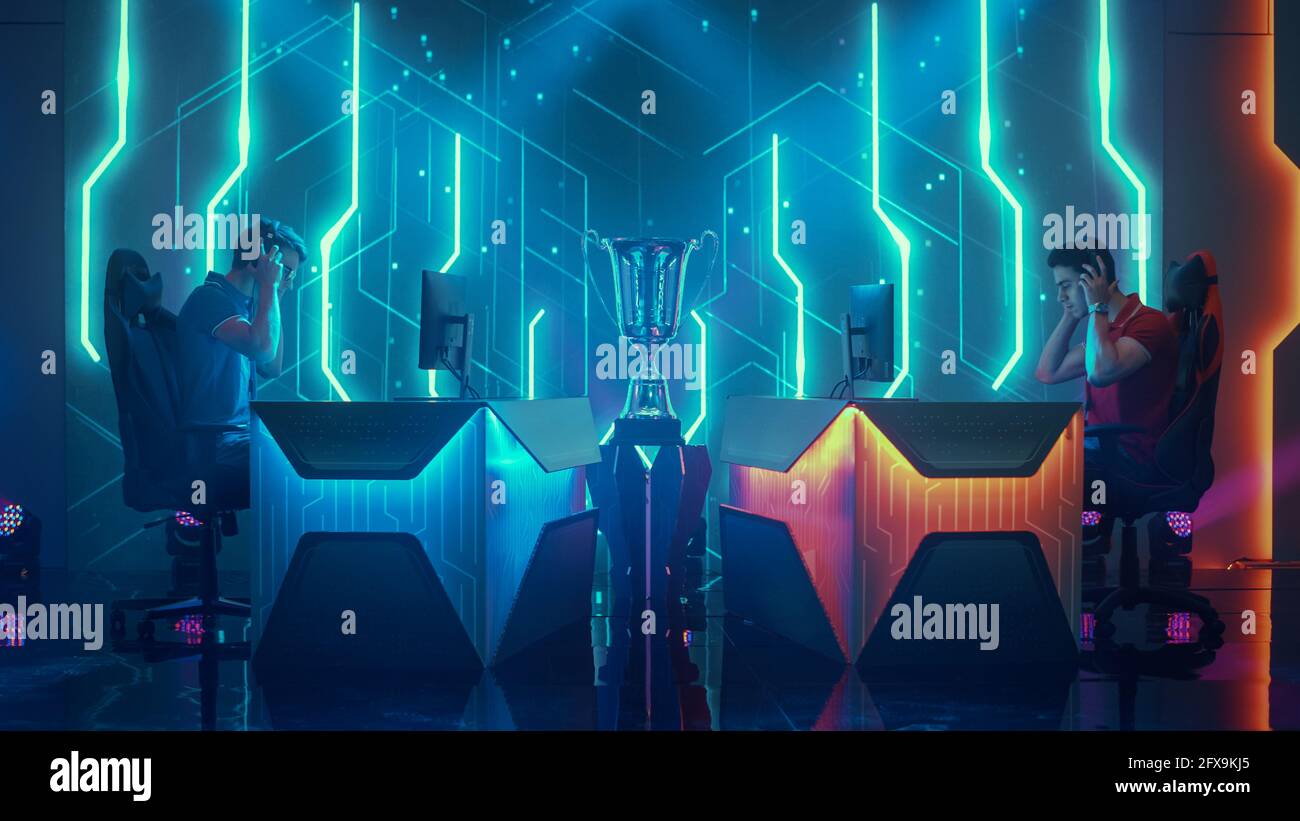 Zwei professionelle eSports-Spieler finden an Gaming-Stationen statt, setzen Kopfhörer auf, Prapare for Game auf einem Cyber Games Championship Event Stockfoto