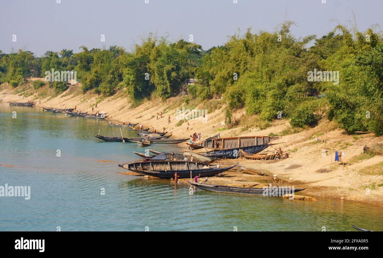 Nicht identifizierte Bengali machen während der Trockenzeit die Wäsche und reparieren ihre Boote am Ufer des Flusses Sari. Sylhet, Bangladesch Stockfoto