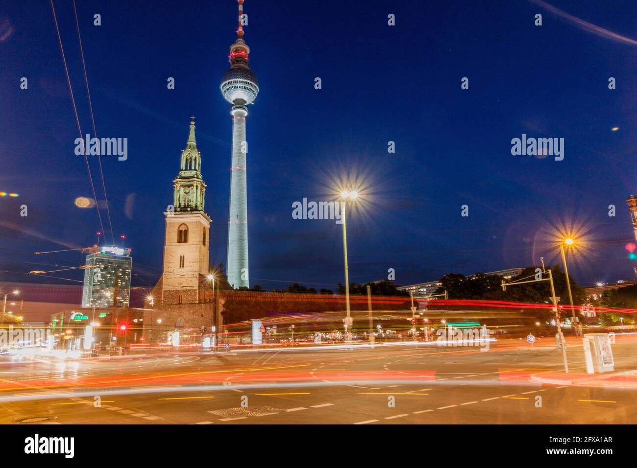 BERLIN, DEUTSCHLAND - 9. AUGUST 2017: Abendansicht der Marienkirche und des Fernsehturms mit verwaschenem Verkehrslicht. Stockfoto