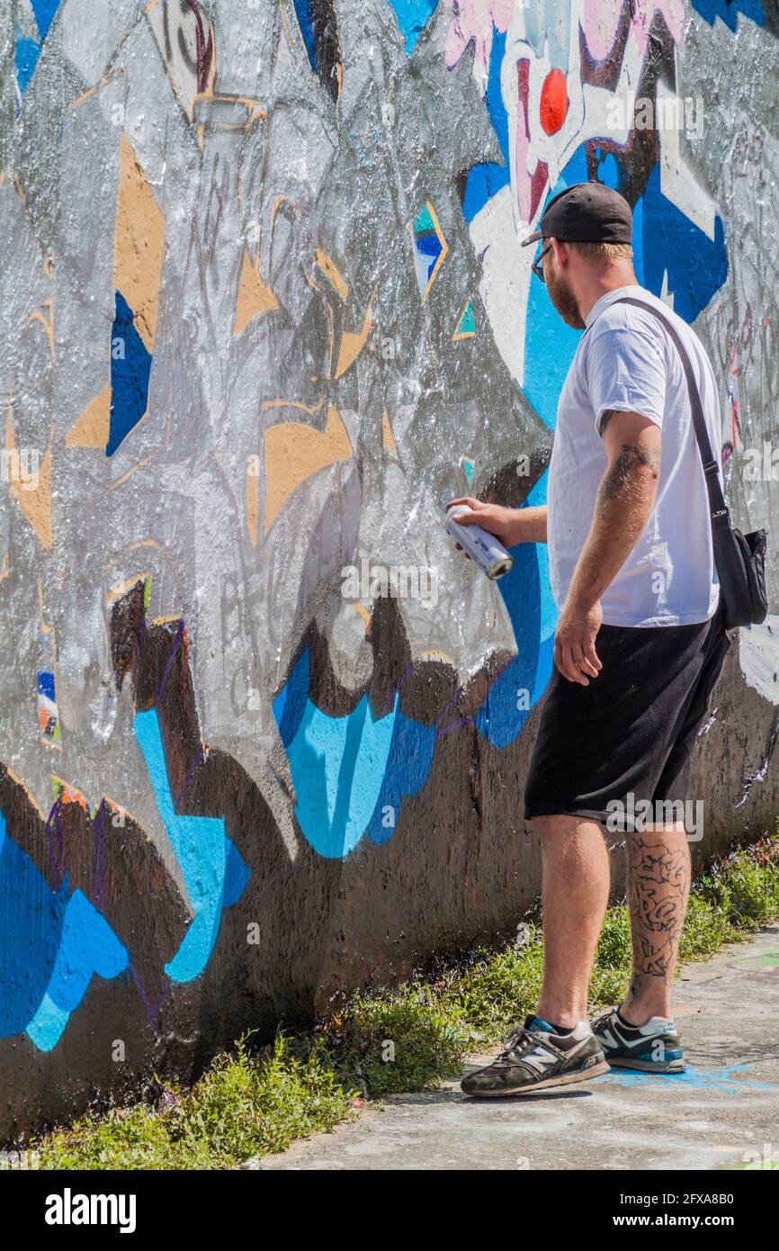 BERLIN, DEUTSCHLAND - 6. AUGUST 2017: Graffiti-Künstler malen auf einem Abschnitt der Berliner Mauer im Mauerpark. Stockfoto