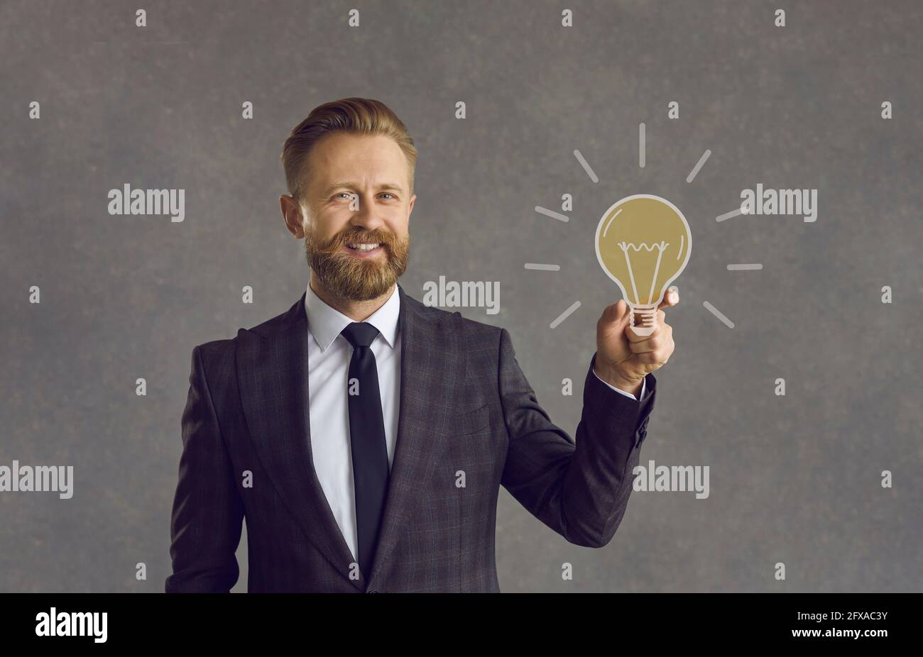 Glücklicher Geschäftsmann, der Glühbirne als Konzept für Geschäftsidee, Lösung und Innovation hält Stockfoto