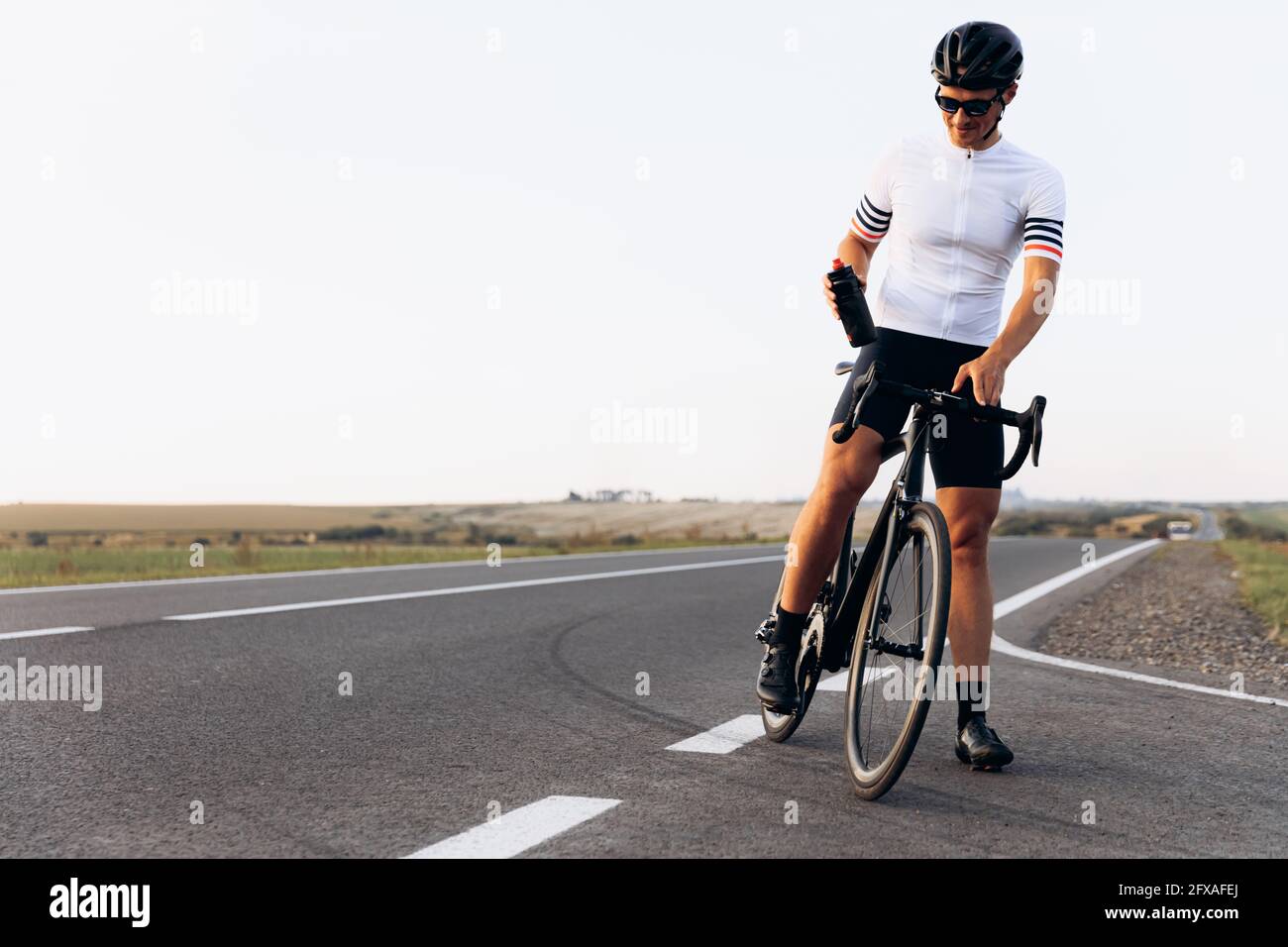 Fröhlicher Radfahrer im Sport-Outfit im Freien stehen Stockfoto