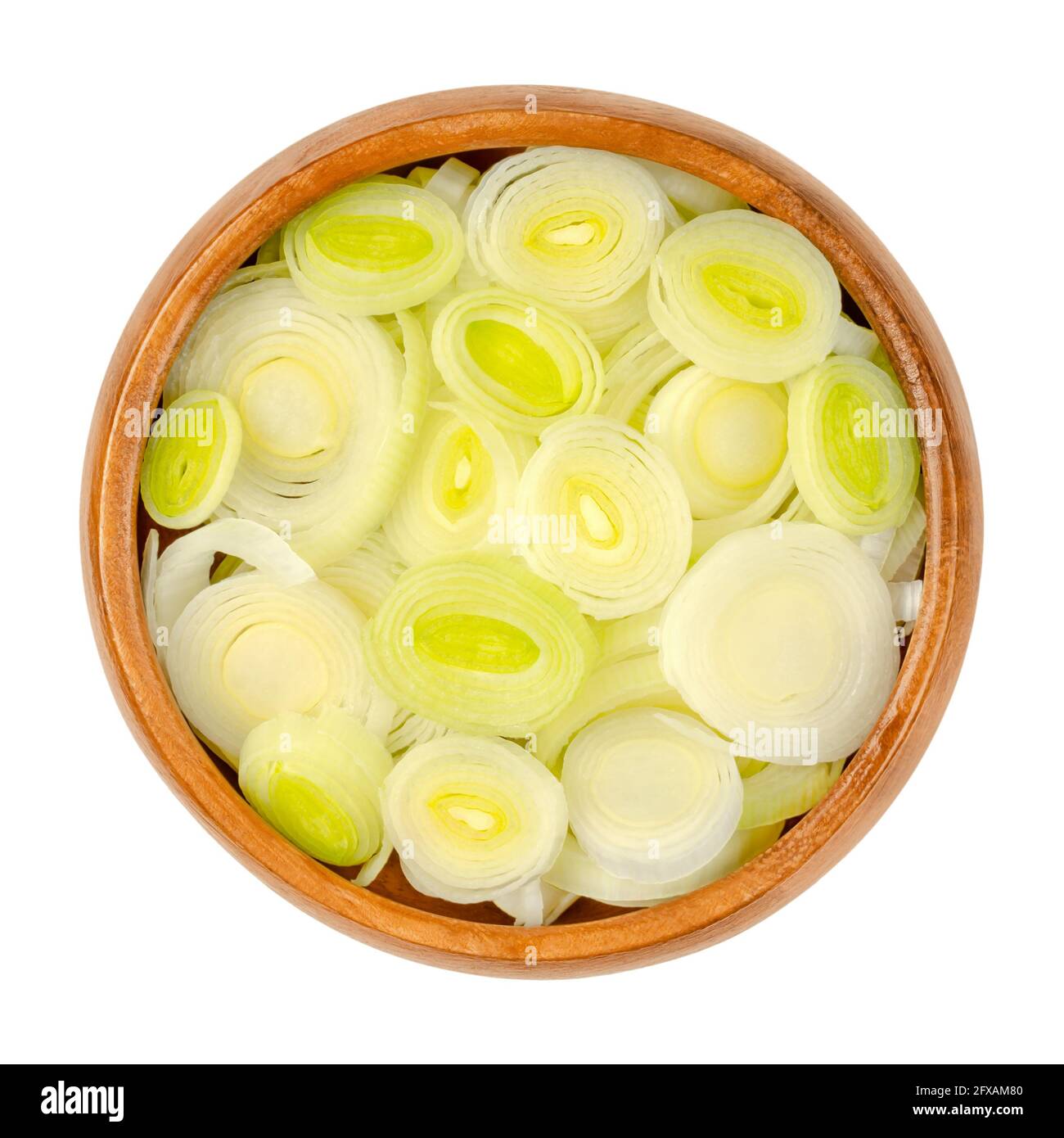 Porree in Scheiben, in einer Holzschale. Gehackte Blattscheiden und Querschnitte von Allium ampeloprasum, einem knackigen und festen Gemüse. Stockfoto