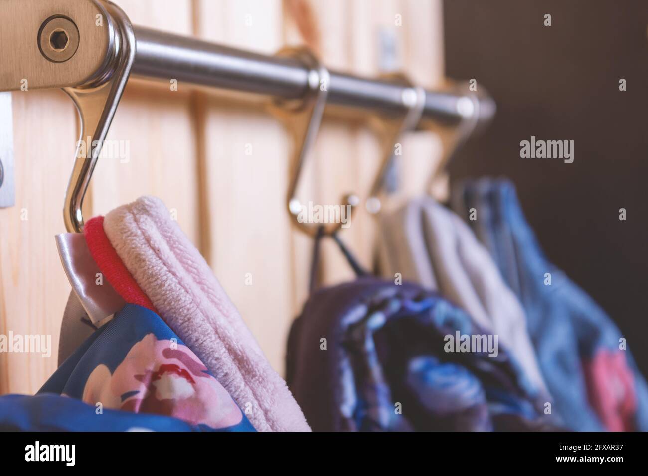 Kleiderbügel für Kinder an Metallhaken. Nahaufnahme. Stockfoto