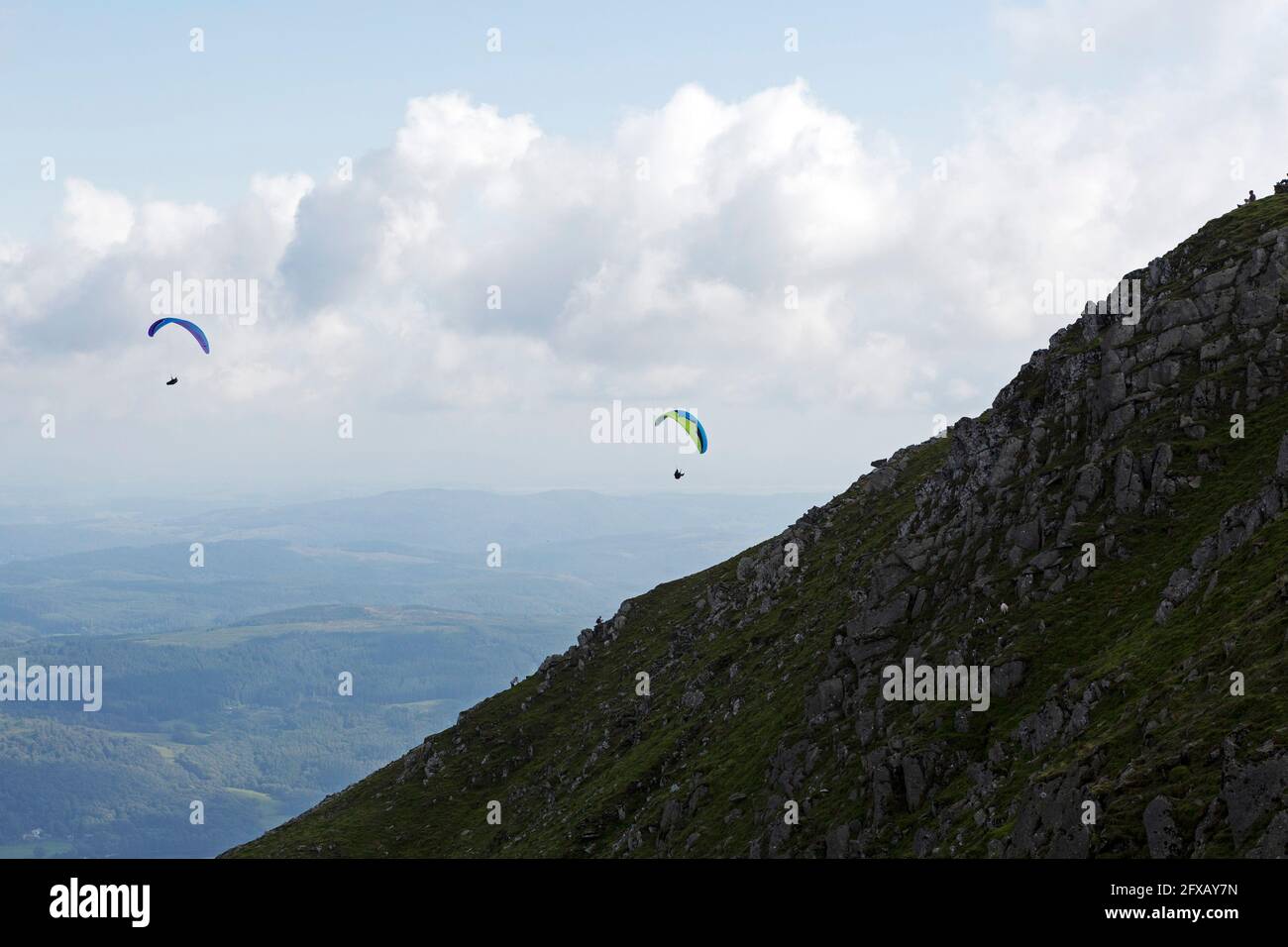 Gleitschirmflieger in der Nähe des alten Mannes von Coniston in Cumbria, England. Der Fell liegt im englischen Lake District. Stockfoto