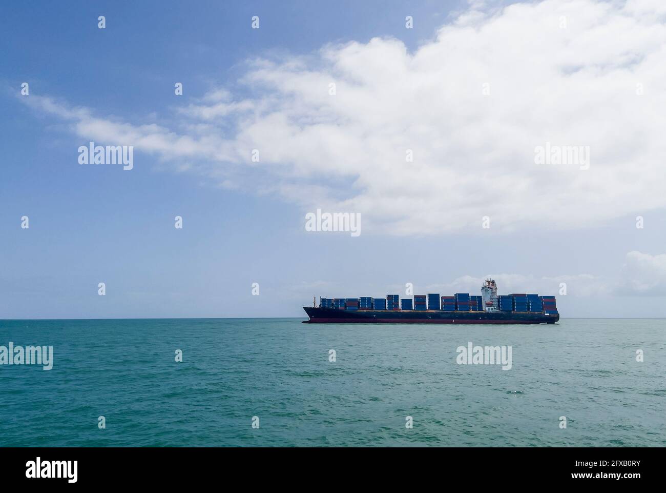 Containerschiff oder Containerschiff mit Containern Fracht auf den Wellen des Indischen Ozeans in der Nähe des Hafens von Sansibar. Container Seeschifffahrt und t Stockfoto