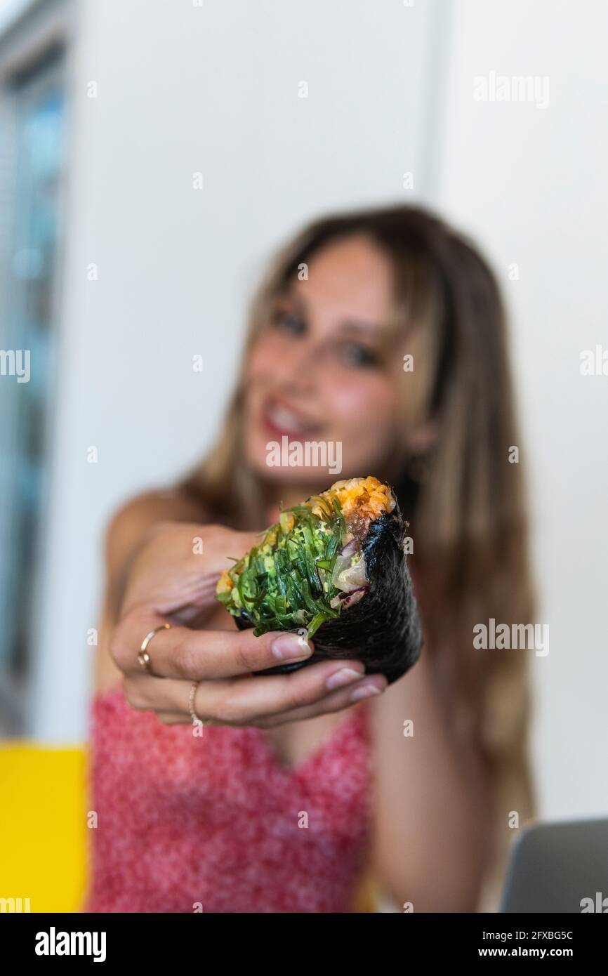 Junge Frau hält Essen im Restaurant Stockfoto