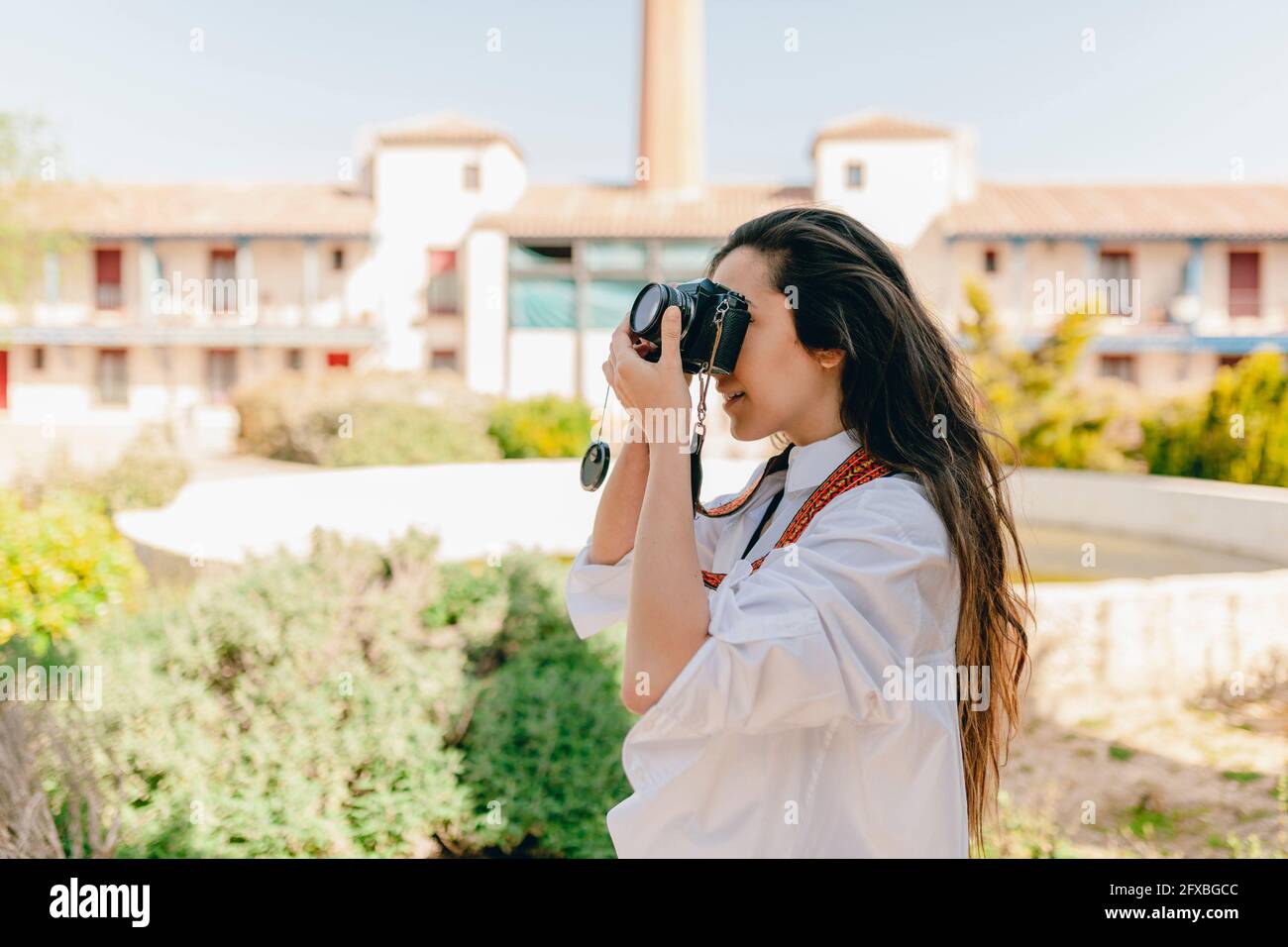 Frau, die im Dorf mit der Kamera fotografiert Stockfoto