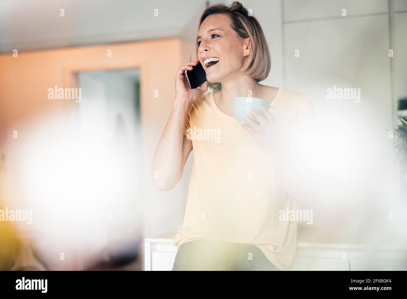 Kurzhaarige Frau, die zu Hause telefoniert Stockfoto