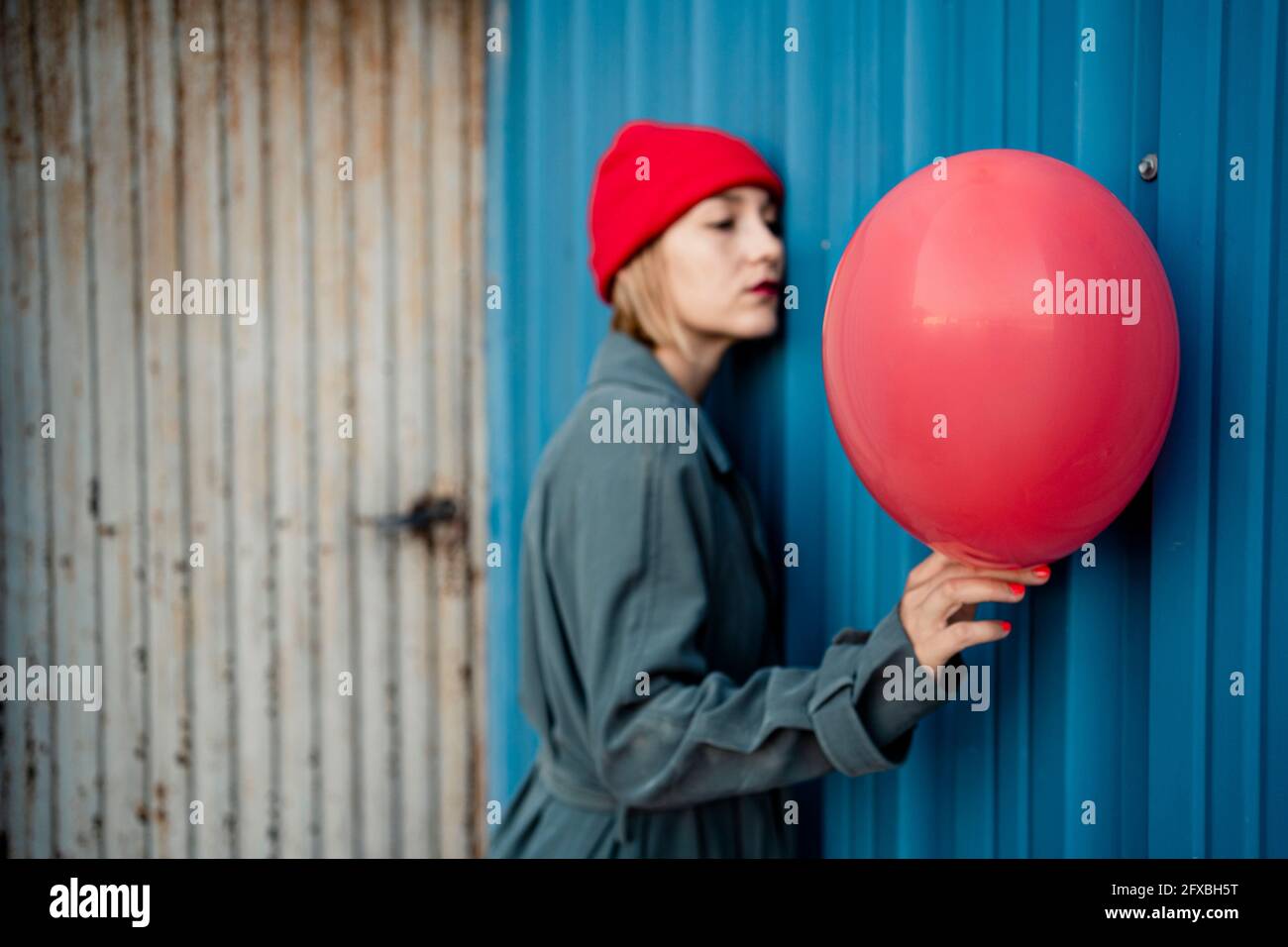 Frau trägt Strickmütze mit Ballon durch blauen Verschluss Stockfoto