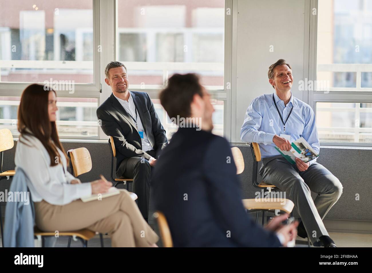 Lächelnder männlicher Unternehmer mit Kollegen in der Ausbildungsklasse Stockfoto