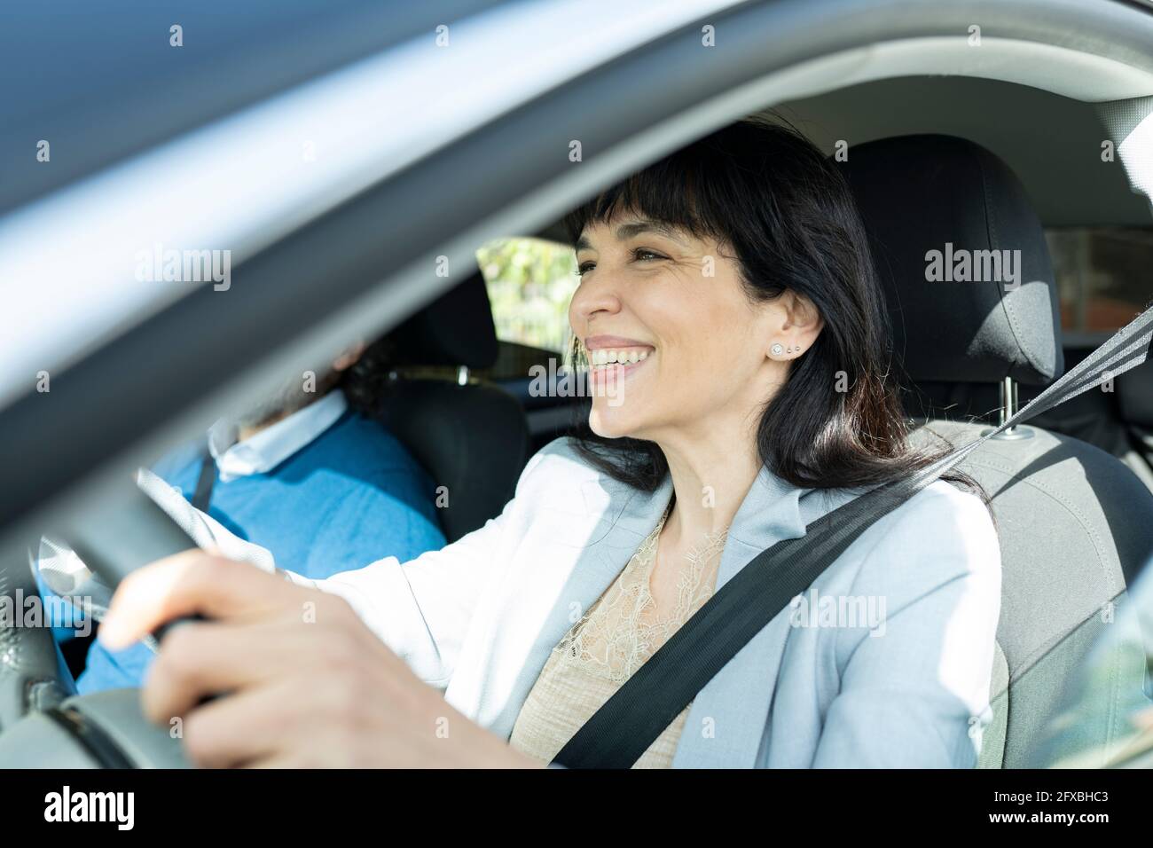 Lächelnder, reifer Unternehmer, der Auto fährt Stockfoto