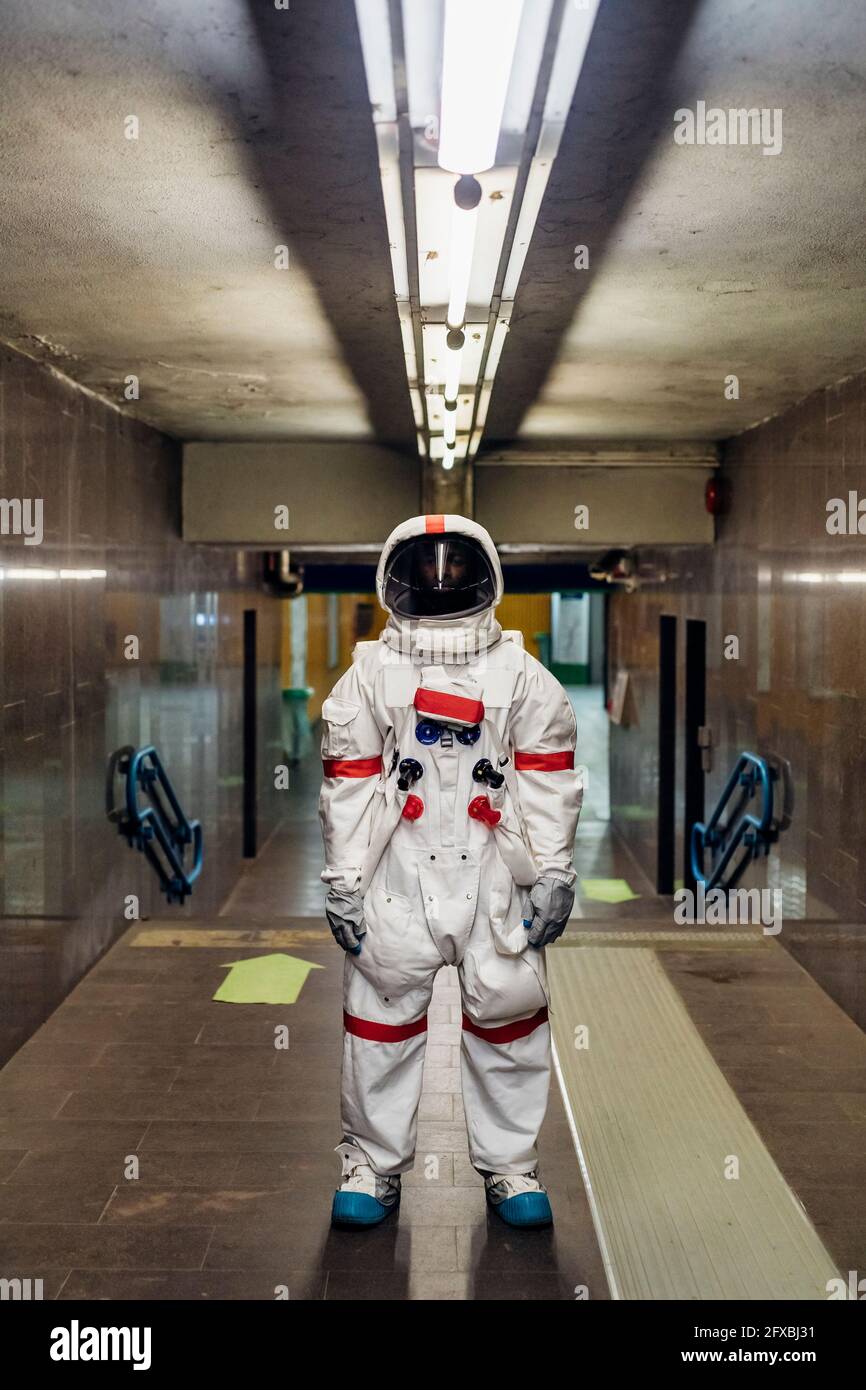 Männlicher Astronaut, der im Keller steht Stockfoto