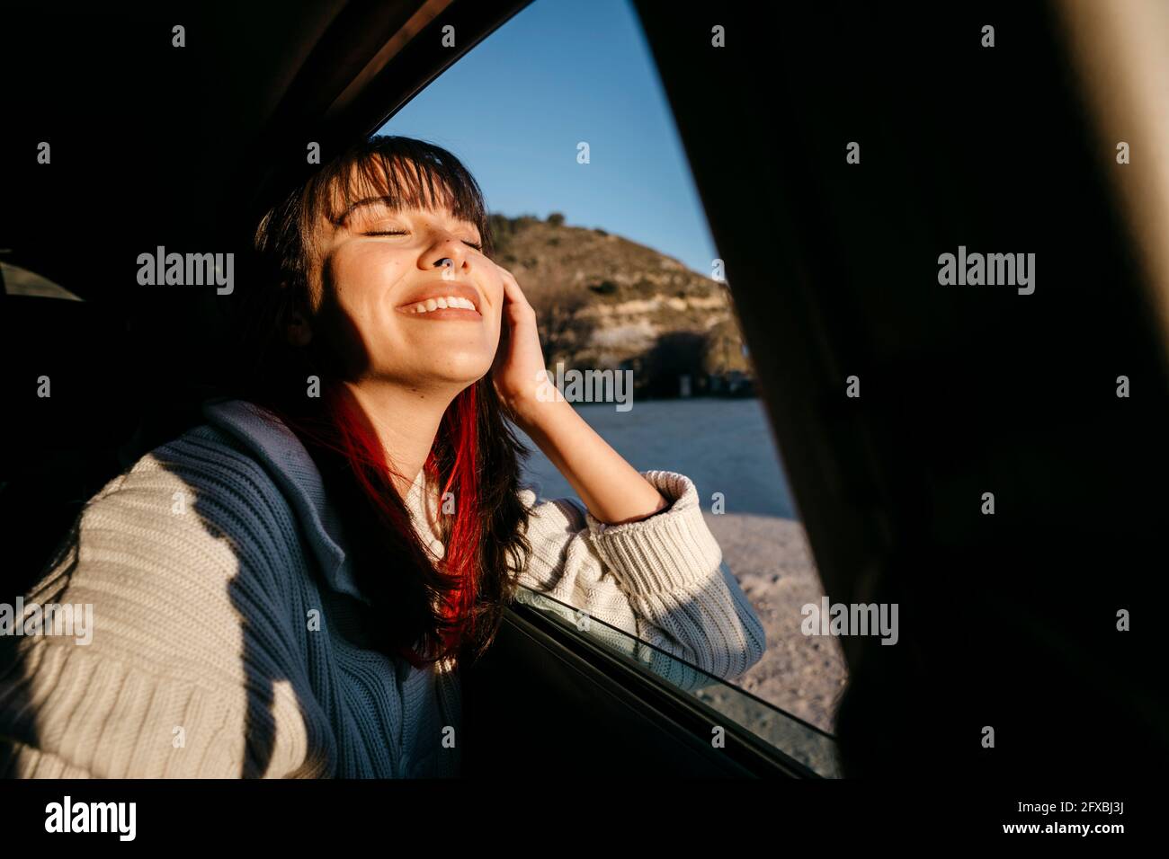 Glückliche Frau mit geschlossenen Augen reisen im Auto Stockfoto