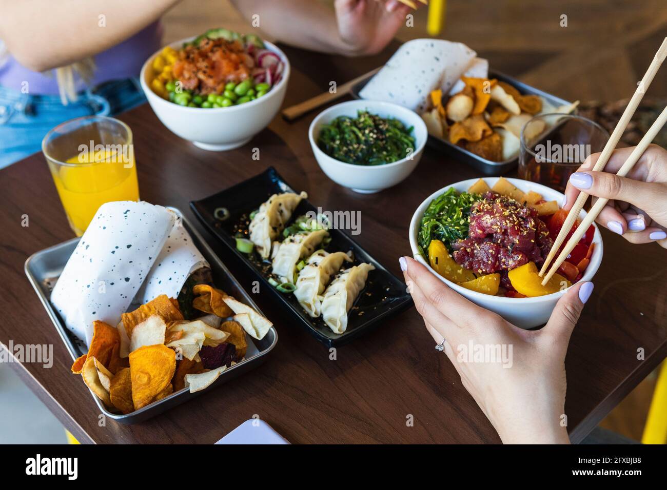 Junge Frau beim Essen mit einer Freundin im Restaurant Stockfoto