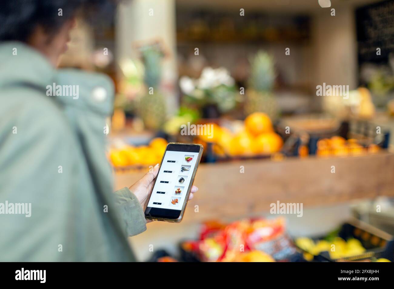 Frau kauft Lebensmittel über mobile Anwendung im Supermarkt Stockfoto