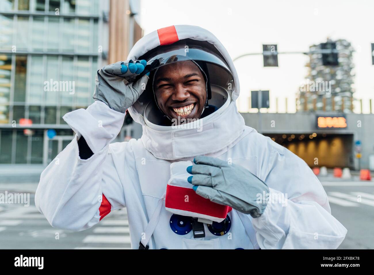 Fröhlicher männlicher Astronaut mit Weltraumhelm Stockfoto