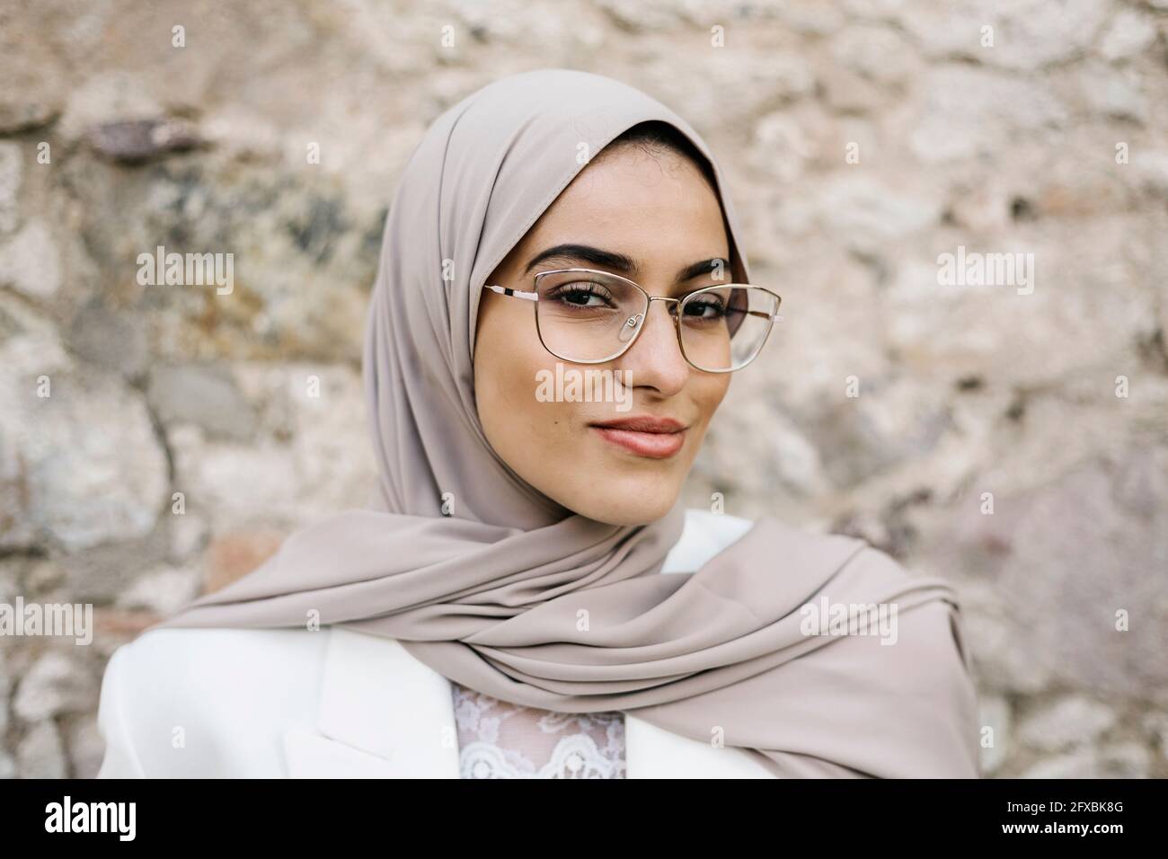 Schöne Frau mit Kopftuch und Brille vor der Wand Stockfotografie - Alamy