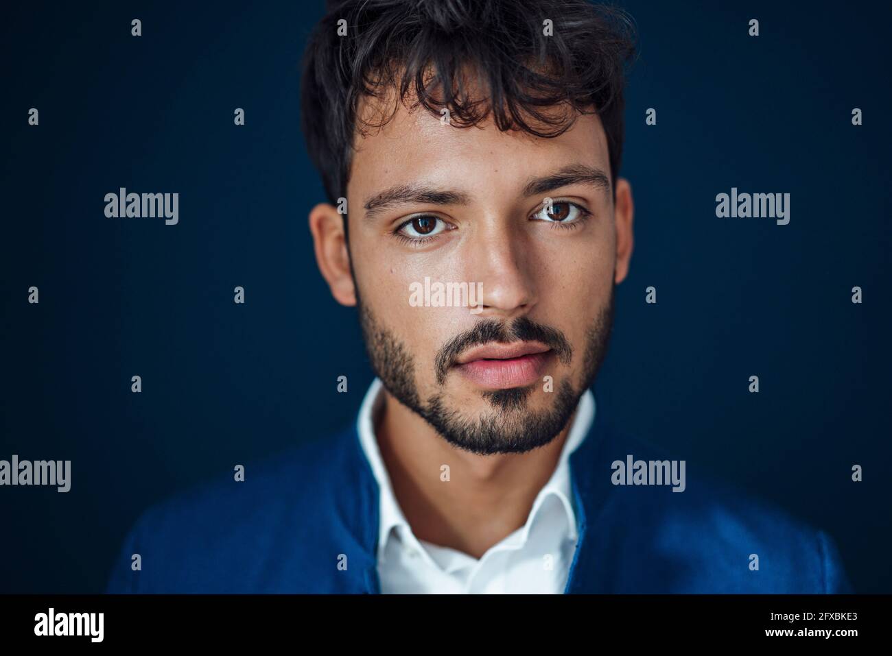Hübscher junger Mann vor blauem Hintergrund Stockfoto