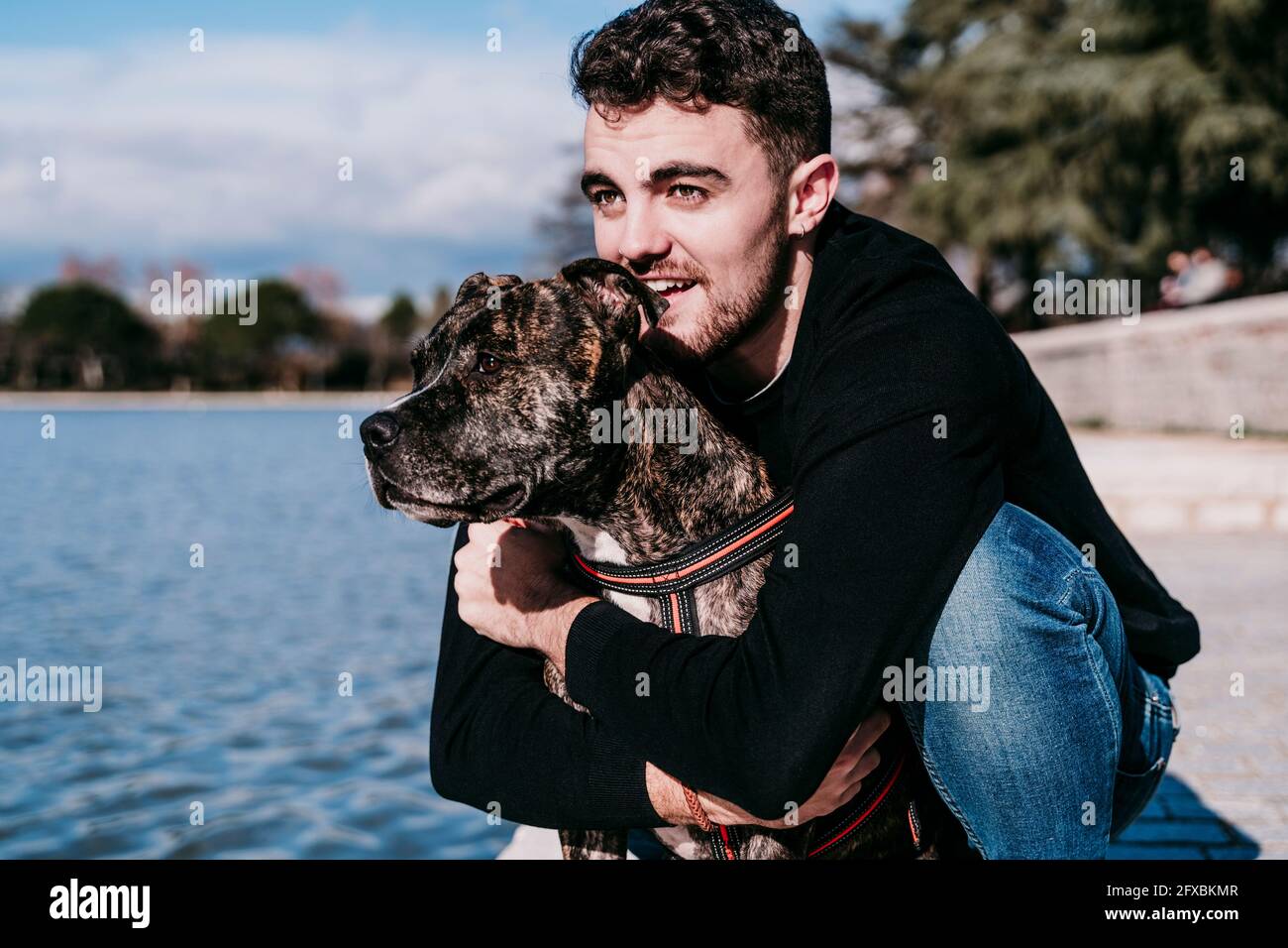 Mann umarmt Haustier an sonnigen Tag Stockfoto