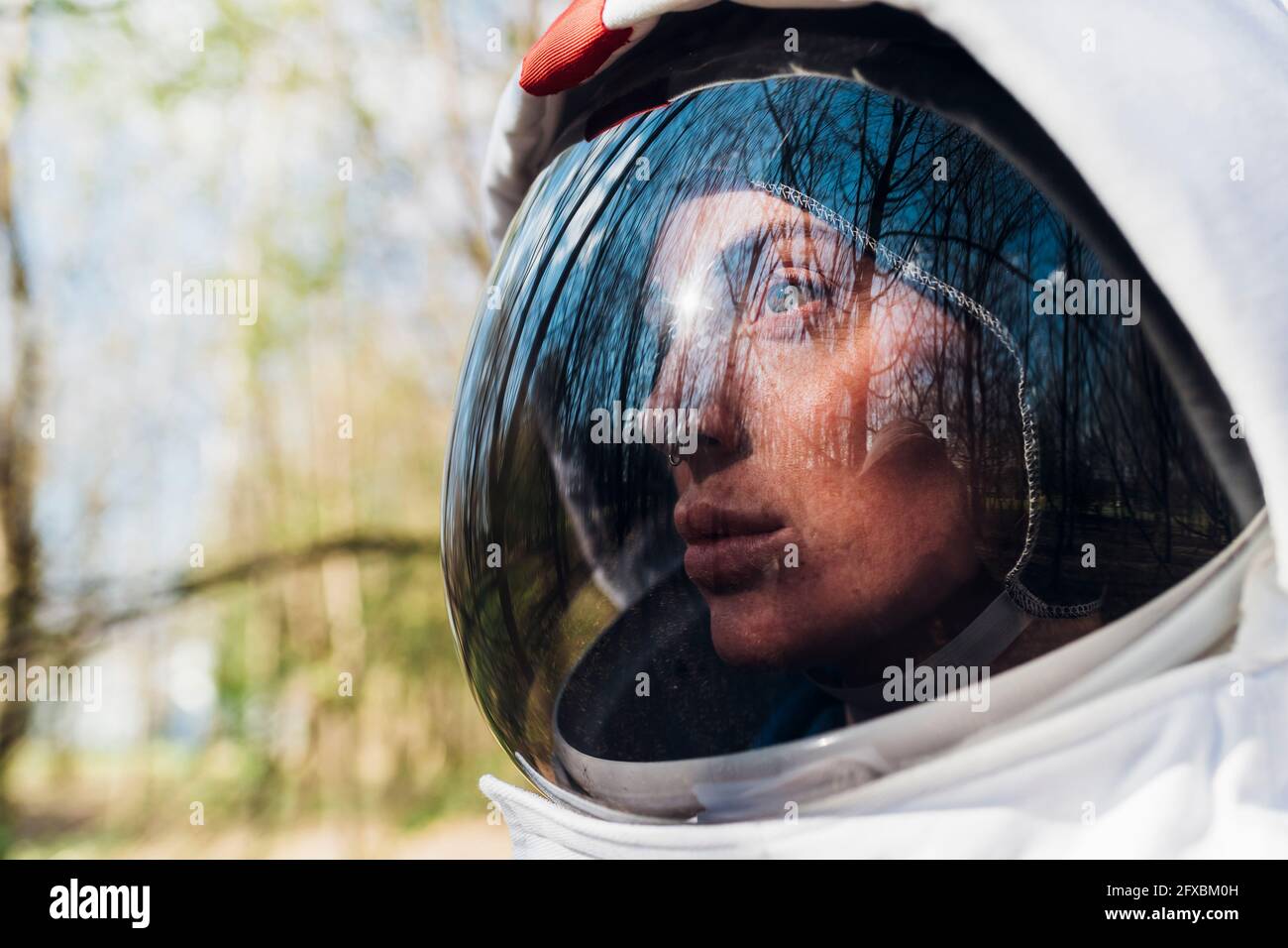 Weibliche Astronautin trägt Weltraumhelm wegschauen Stockfoto