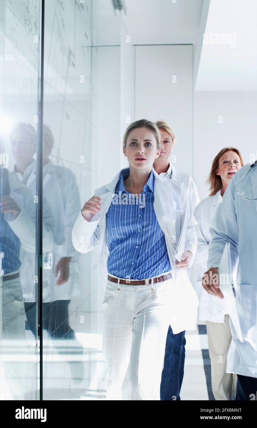 Weibliche und männliche Ärzte, die während der Dringlichkeit im Krankenhaus herunterlaufen Stockfoto