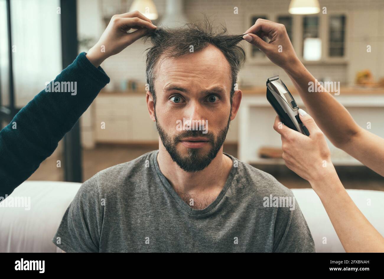 Verwirrt Mann mit Haarschnitt zu Hause Stockfoto