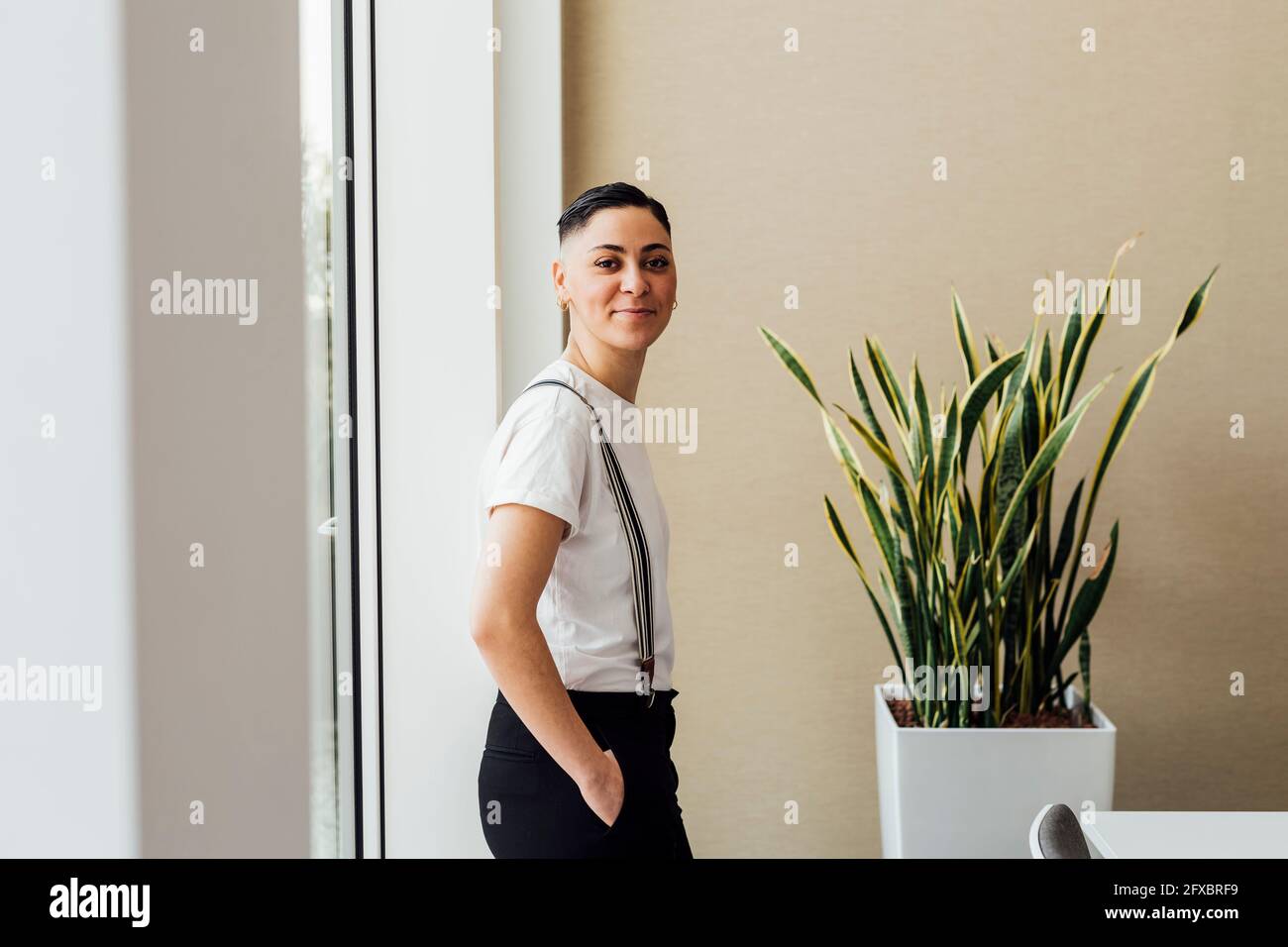 Selbstbewusster Unternehmer, der im Büro mit der Hand in der Tasche steht Stockfoto