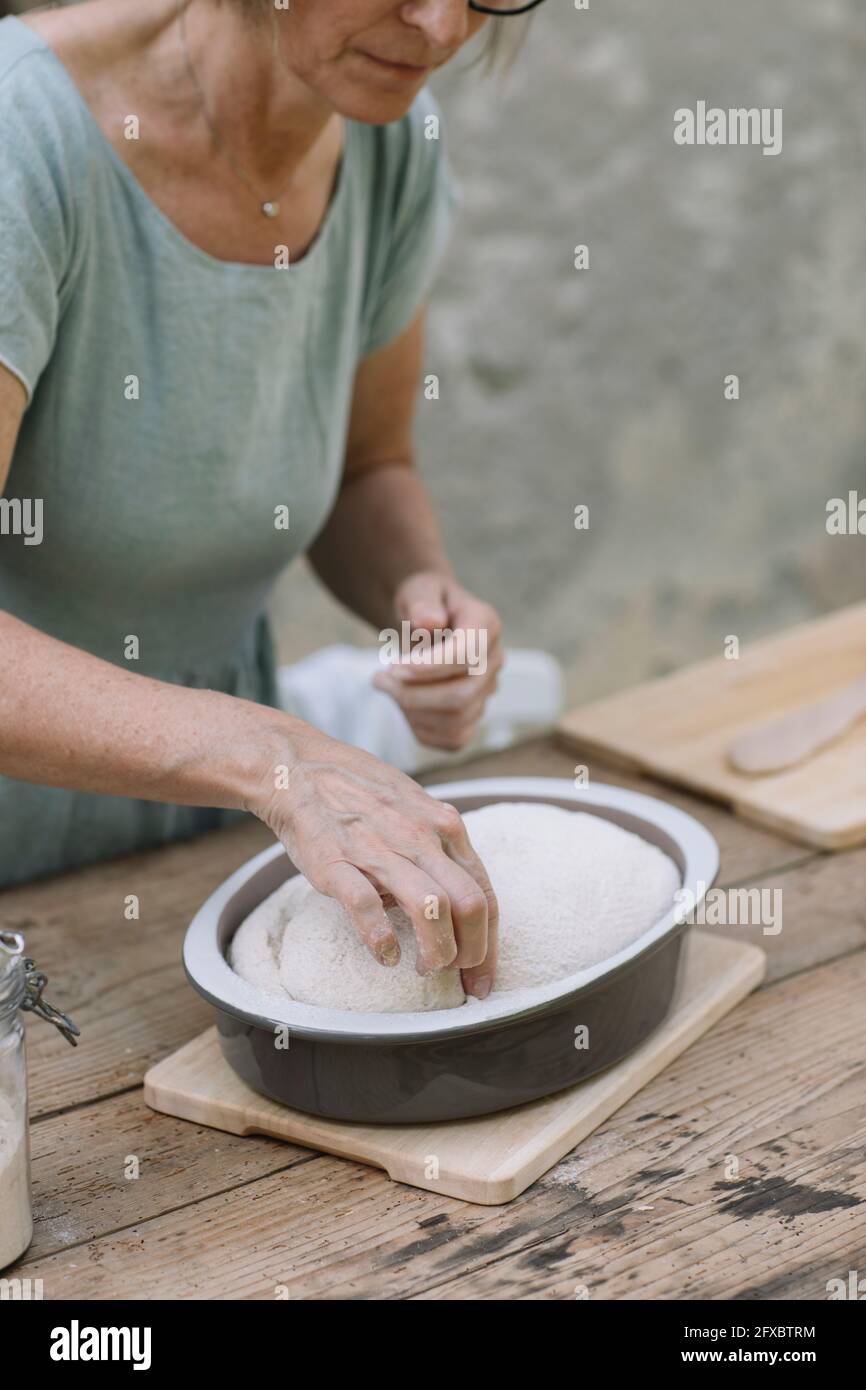 Reife Frau, die gebackenen Teig im Hinterhof überprüft Stockfoto