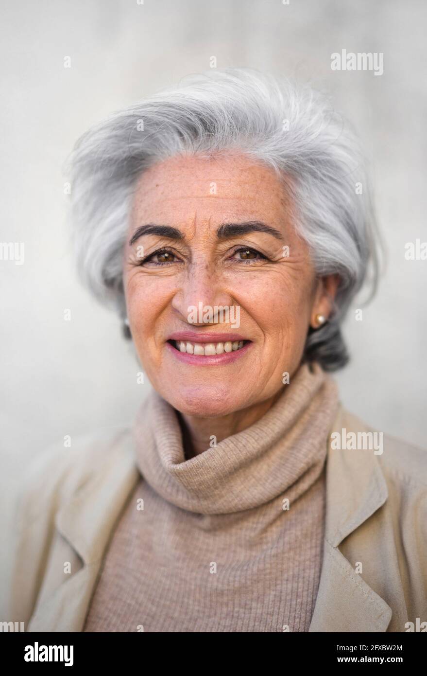 Lächelnde reife Frau mit kurzen Haaren lächelnd Stockfoto
