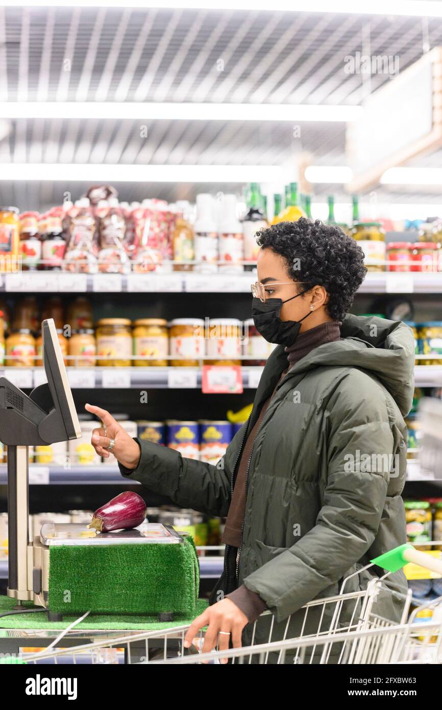 Junge Frau, die im Supermarkt bezahlt Stockfoto