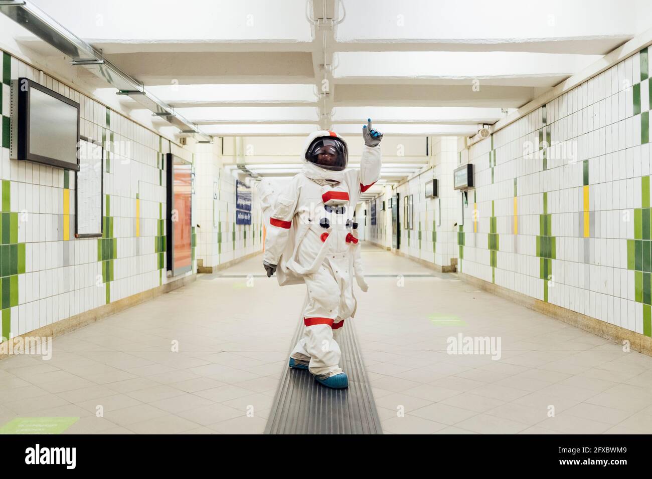 Weibliche Astronautin zeigt, während sie in der U-Bahn steht Stockfoto