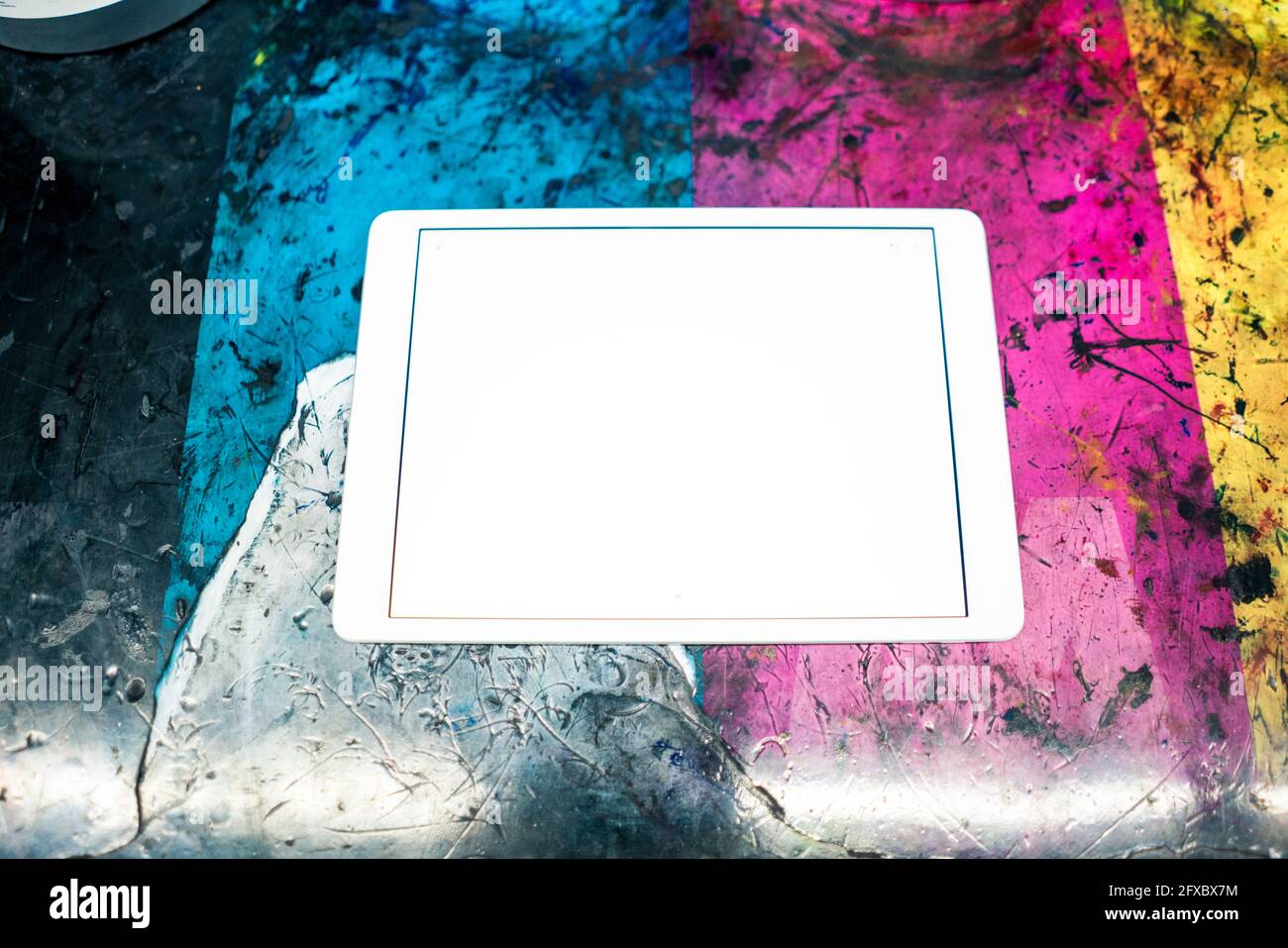 Digitales Tablet auf mehrfarbigem, zerkratztem Tisch Stockfoto