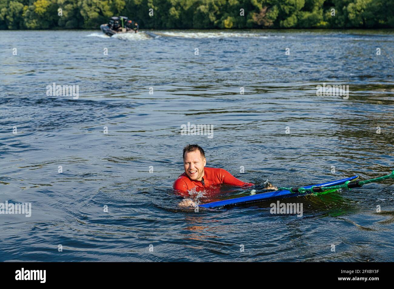 Ein Surfer lächelt beim Schwimmen im Moskva-Fluss vor der Kamera Stockfoto
