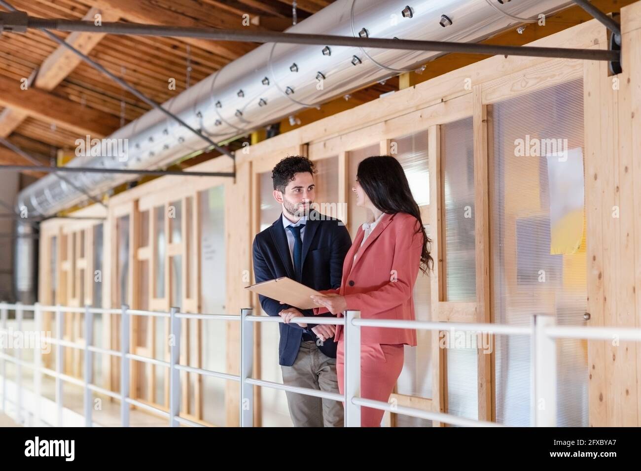 Männliche und weibliche Fachleute diskutieren über den Geschäftsplan im Flur im Büro Stockfoto