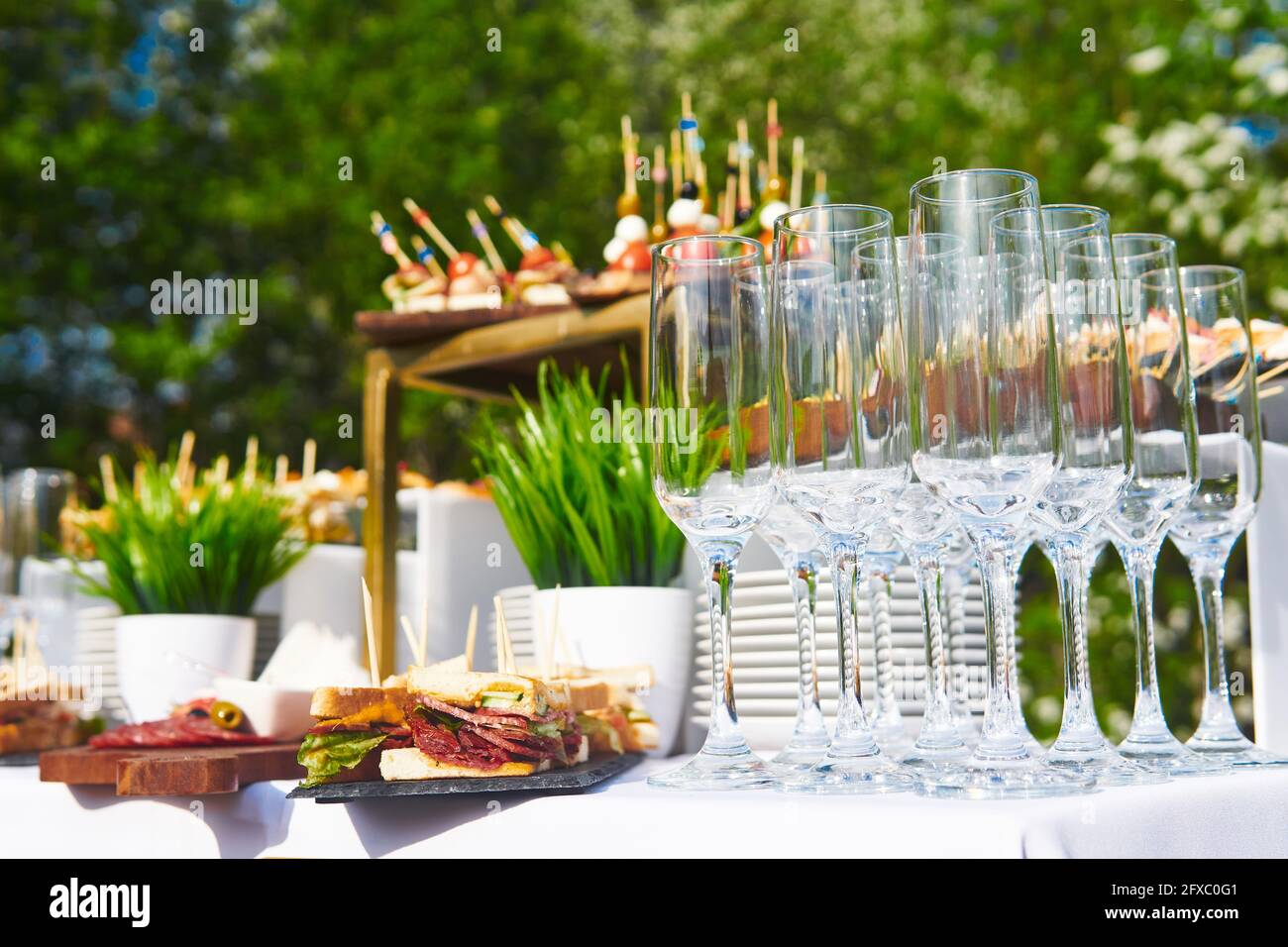 Gläser, Canapes und kalte Snacks auf dem Tisch, während Sie auf den Start des Buffets im Freien warten Stockfoto
