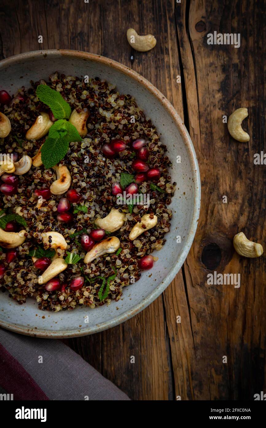 Schüssel mit veganem Quinoa-Salat mit Cashewkernen, Granatapfelkernen und Minze Stockfoto