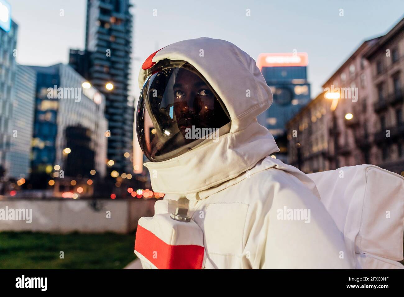 Männlicher Astronaut schaut in der Dämmerung weg Stockfoto