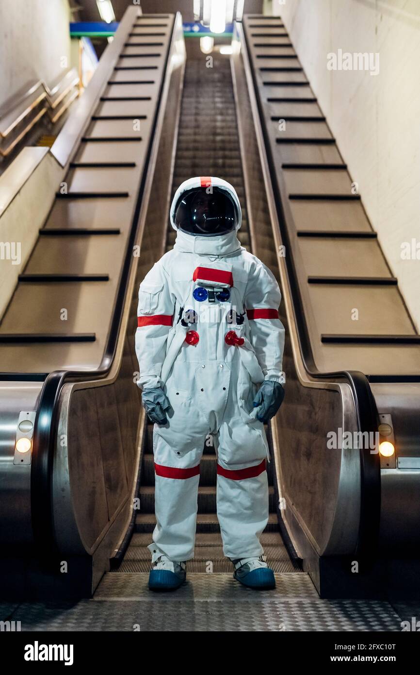 Astronaut mittleren Erwachsenen, der vor der Rolltreppe steht Stockfoto