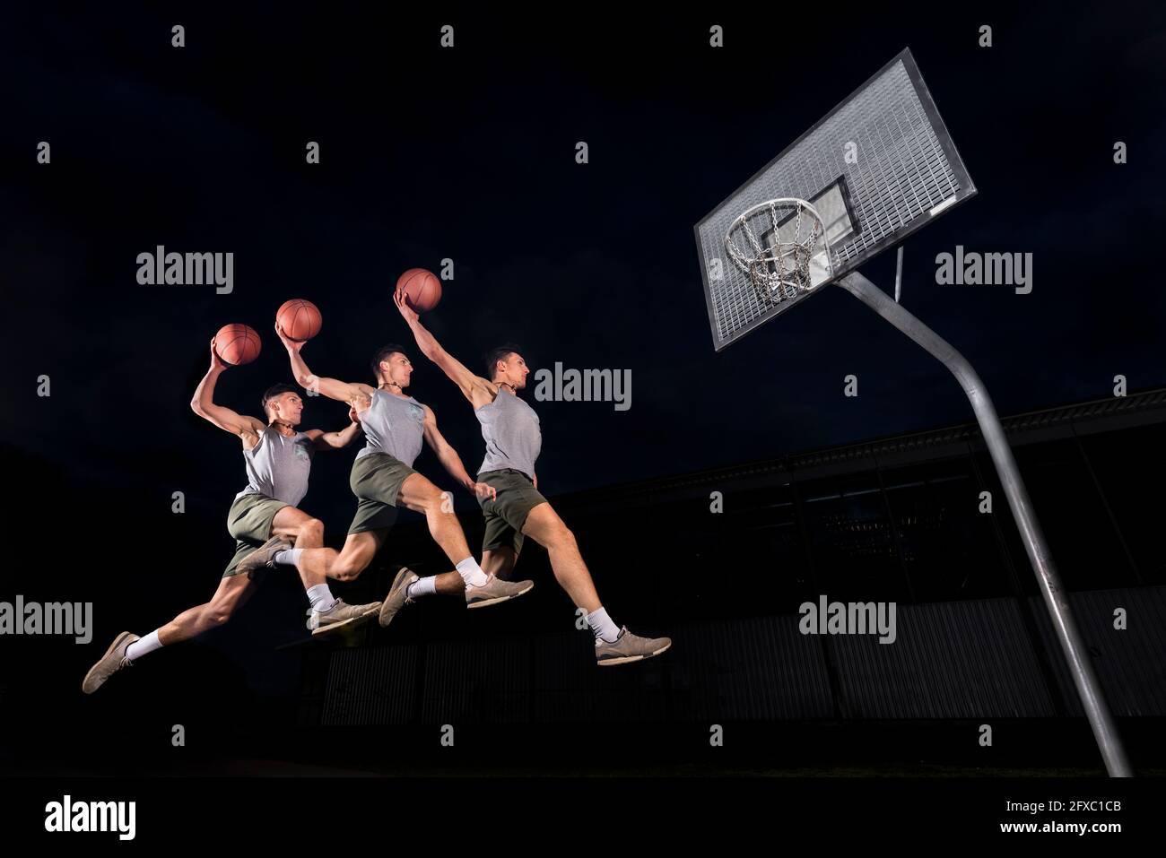 Multiple Bild von jungen Mann springen, während Basketball spielen in der Nacht Stockfoto
