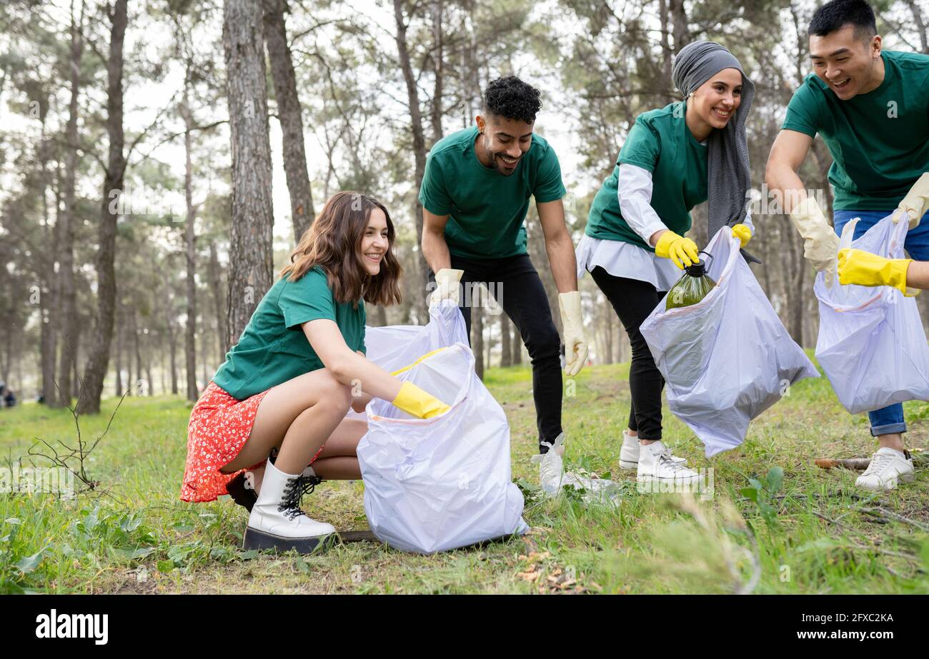 Wohltätigkeitsorganisationen und Hilfskräfte sammeln Müll in Plastiktüten im Wald Stockfoto