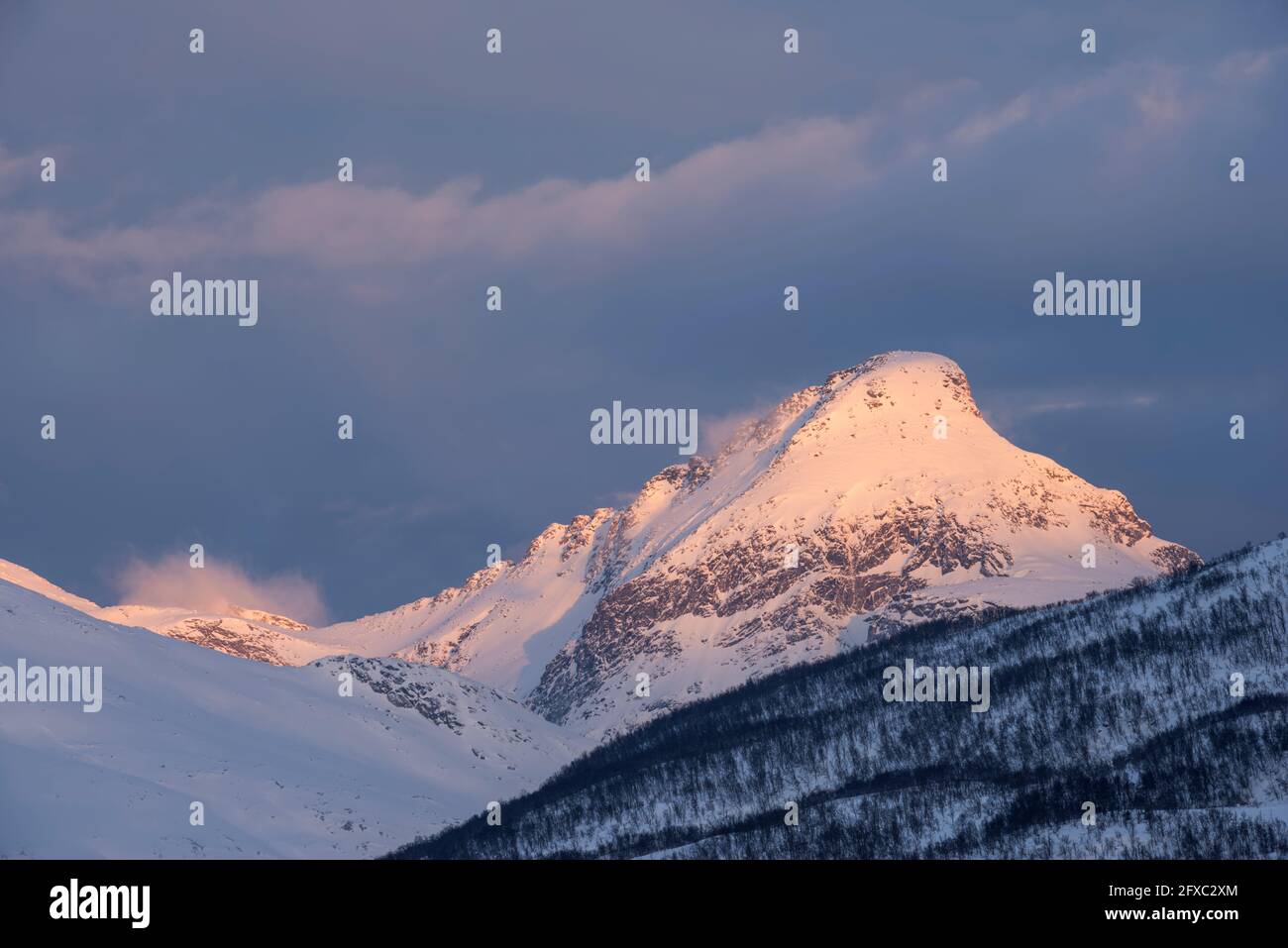 Norwegen, Tromso, schneebedeckter Berggipfel im Sonnenaufgangslicht Stockfoto