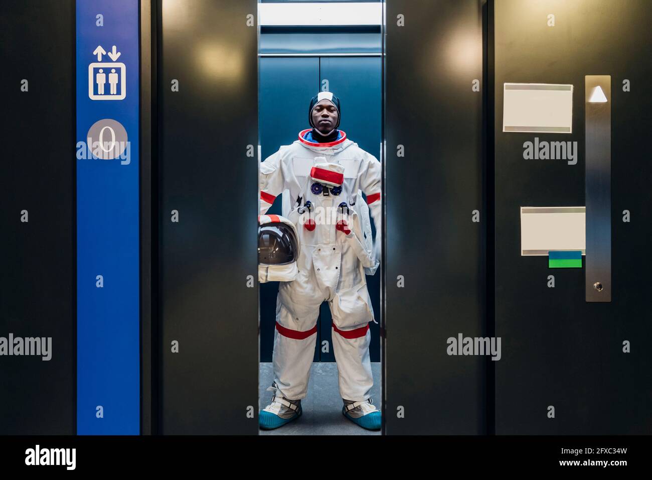 Männlicher Astronaut, der im Aufzug steht Stockfoto
