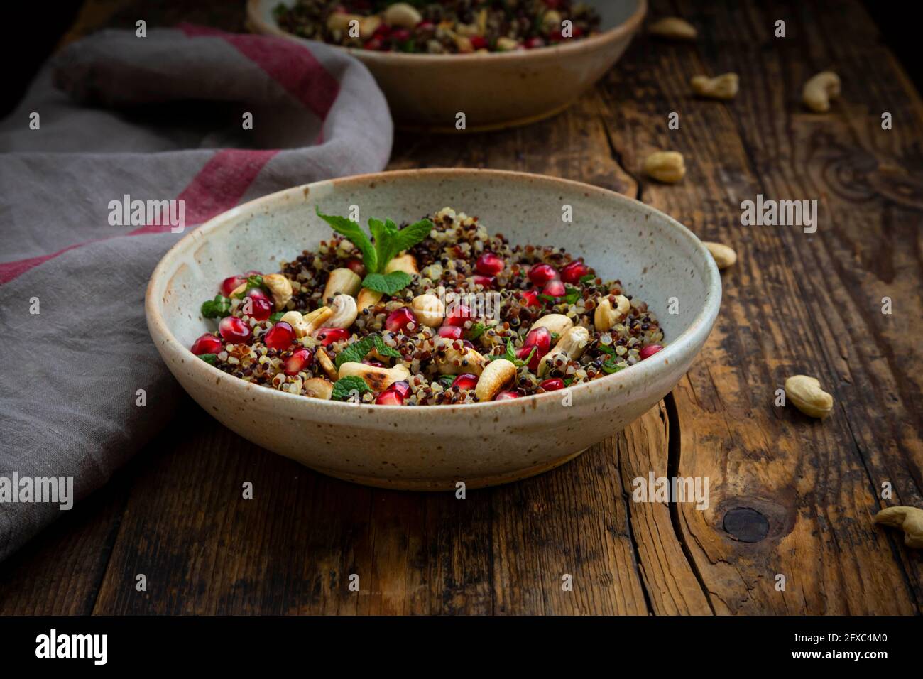 Schüssel mit veganem Quinoa-Salat mit Cashewkernen, Granatapfelkernen und Minze Stockfoto
